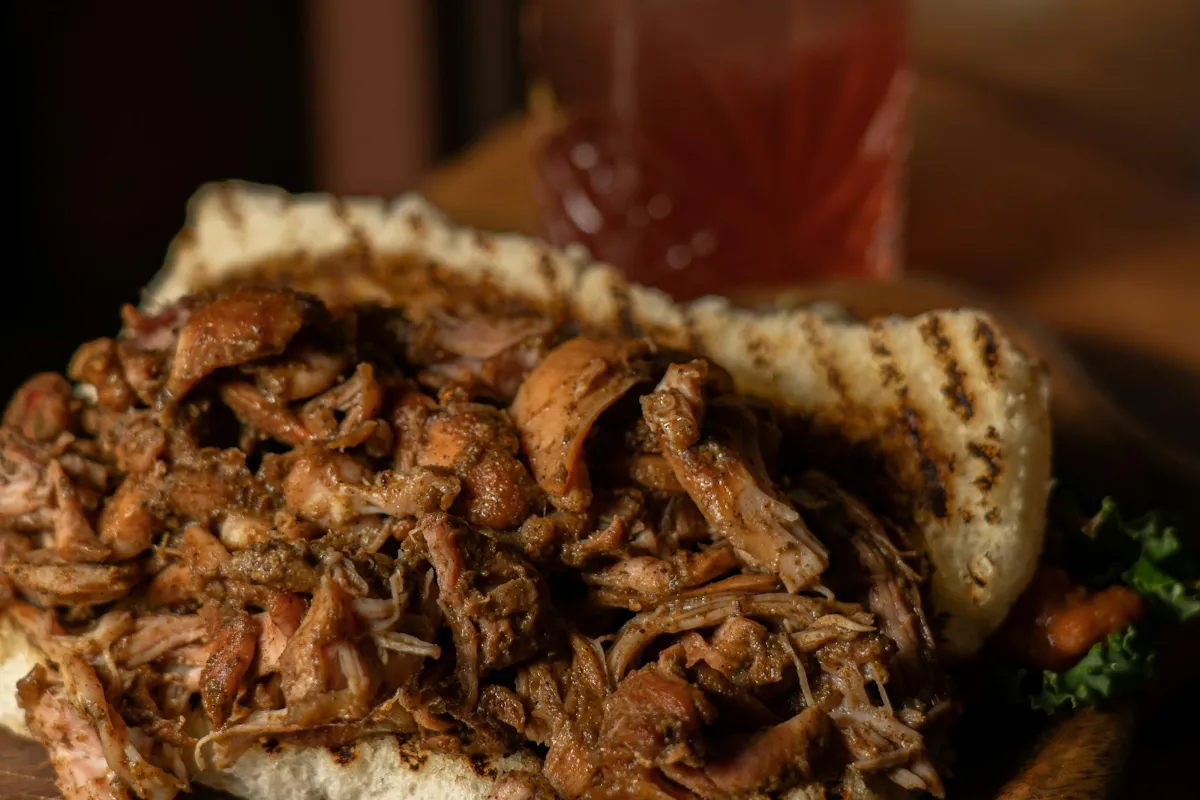 Pulled roast pork piled on an open bread roll