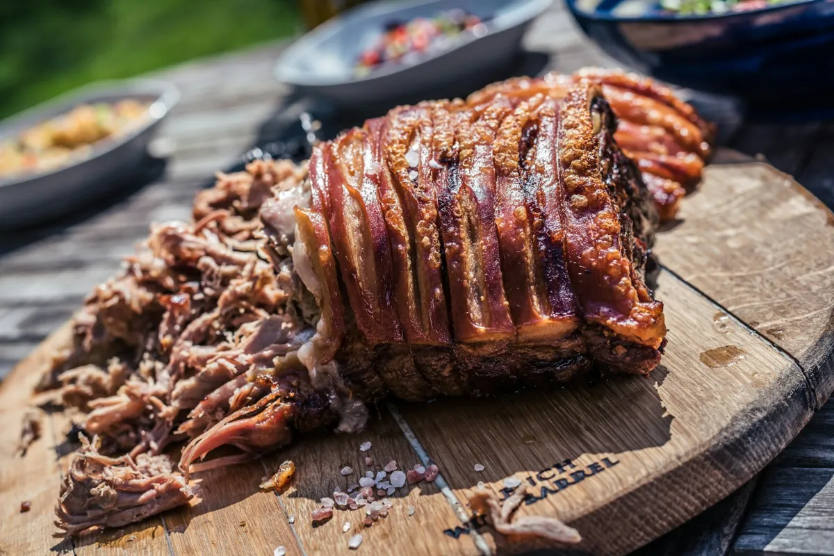 Slow-roasted pork with crackling and pulled pork on a wooden board
